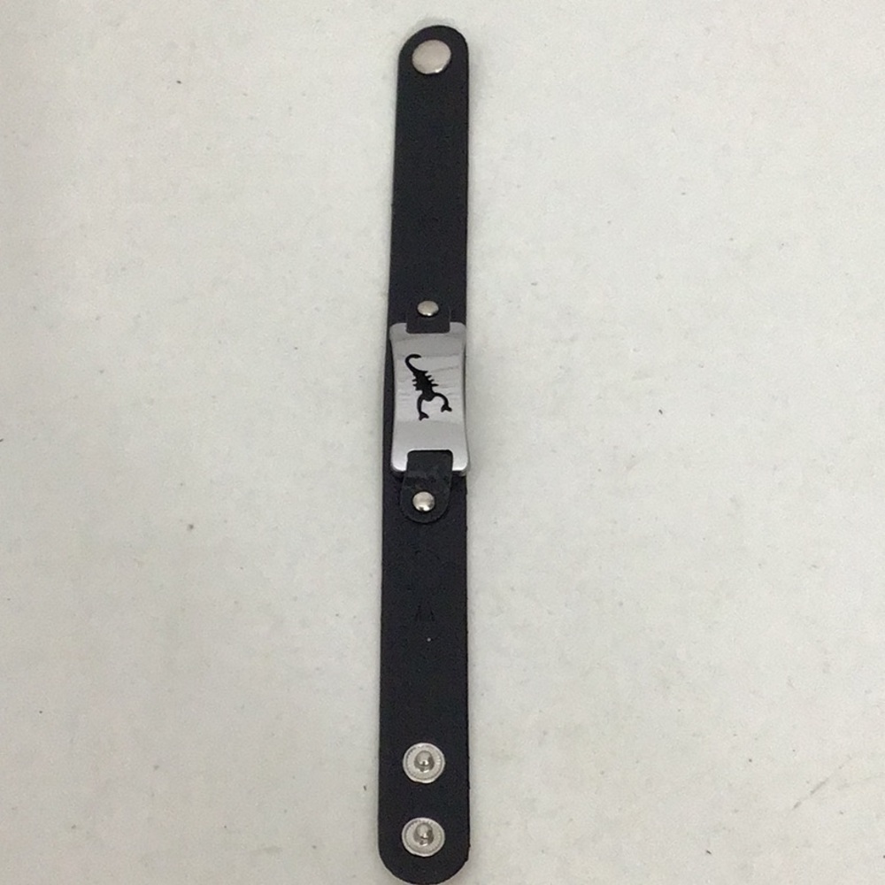 Black leather & stainless steel snap on bracelet w/ scorpion emblem.